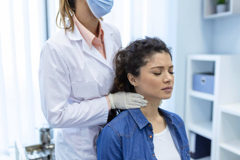 A clinician listens attentively to an older male patient during a consultation.