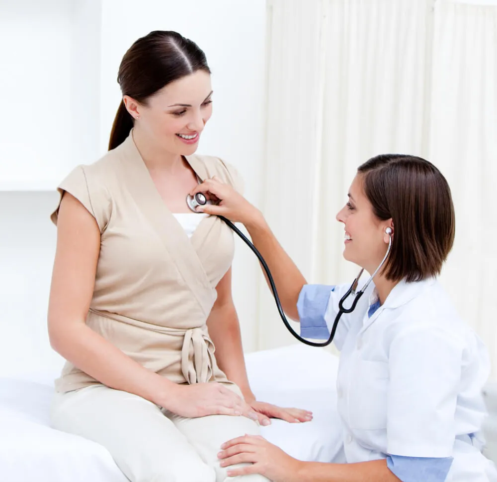 A clinician listens attentively to an older male patient during a consultation.