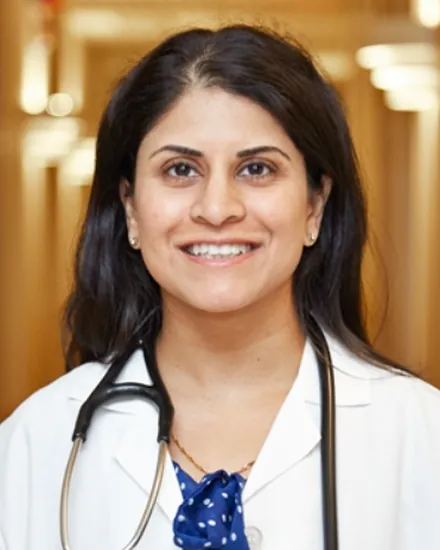 Portrait of Dr. Ashima Bakhru, MD, in a white coat with a stethoscope