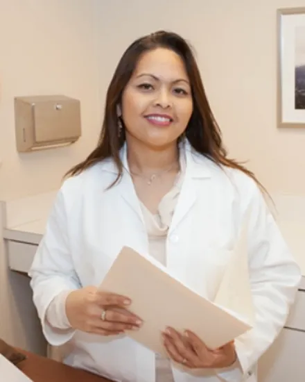 Portrait of Dr. Kathryn Alcarez, MD, in a white coat holding a folder