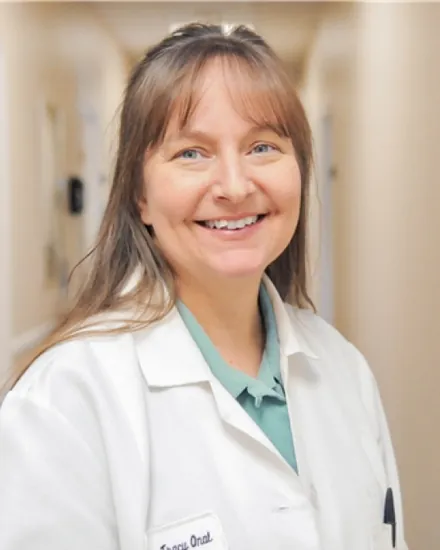 Portrait of Dr. Tracy Onal, DO, smiling in a white coat